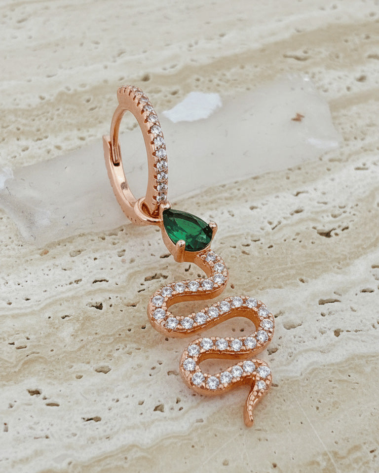 huggie hoop with dangling snake shape plated with rose gold.
