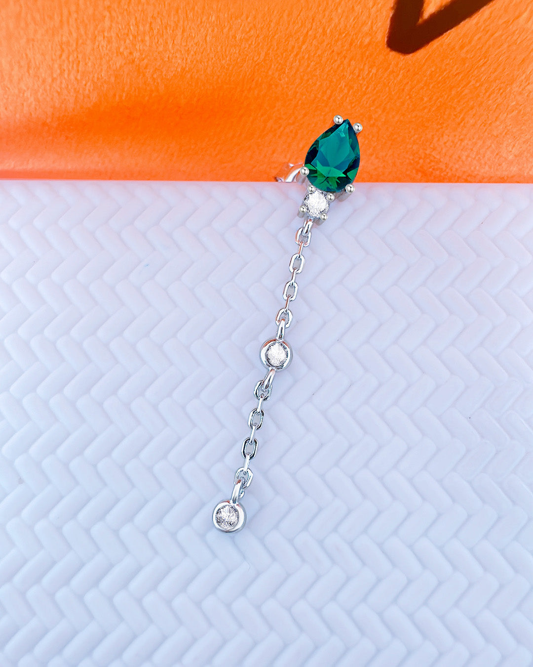 CZ emerald color pear shape stud earring with dngling chain and two white CZ in bezel setting.