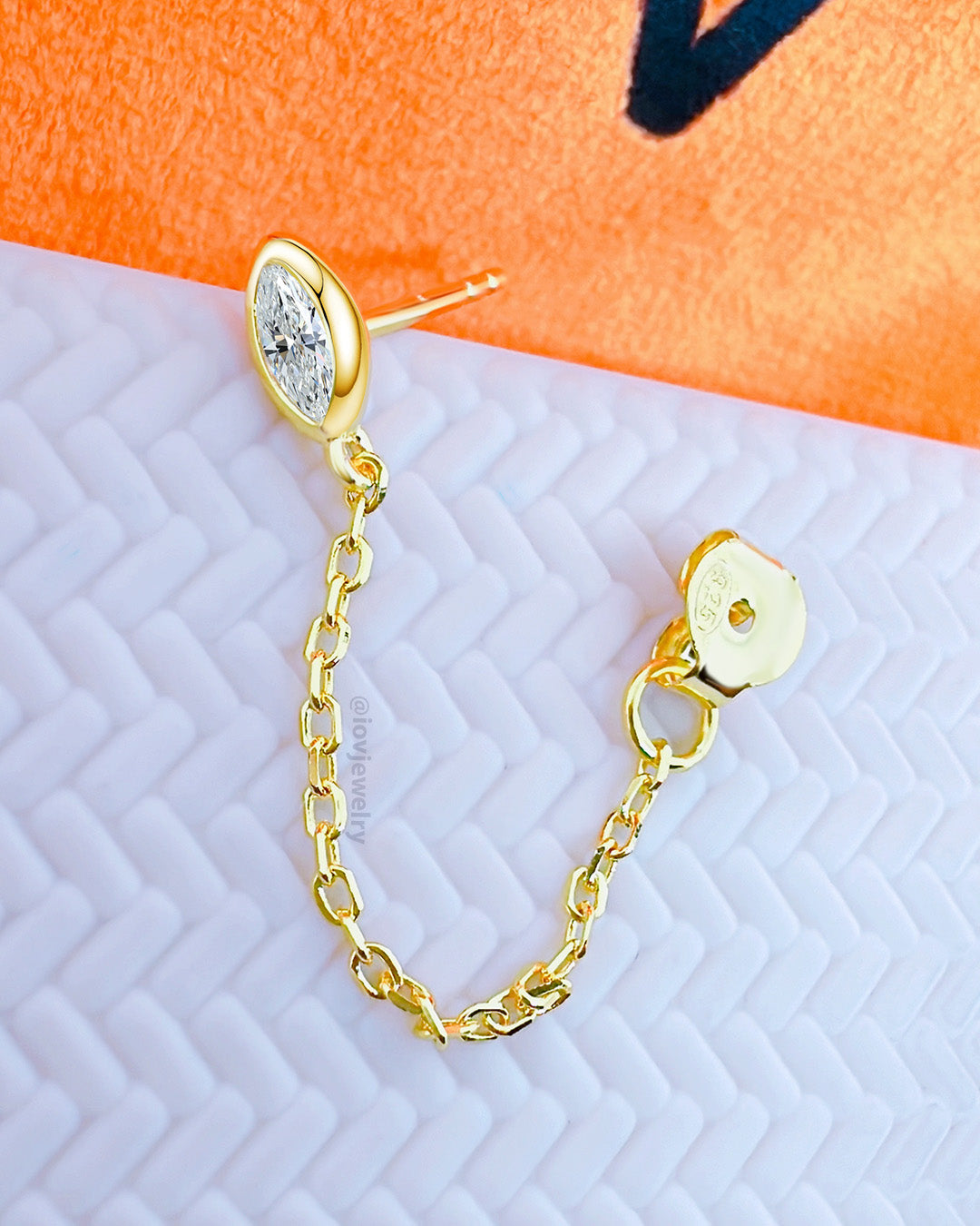 CZ marquise in a bezel setting stud earring with dangling chain linked to stud.