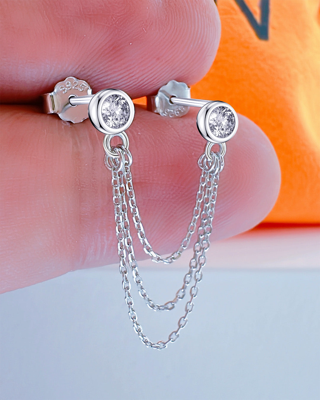 two stud CZ stones in bezel stones linked with triple chains.