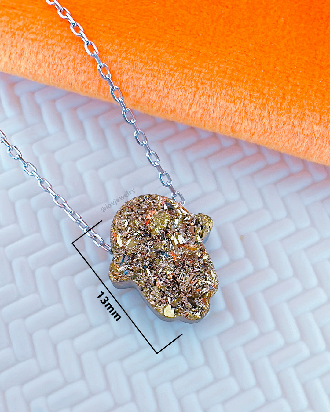 Hamsa shape movable stone multi faceted golden color necklace.