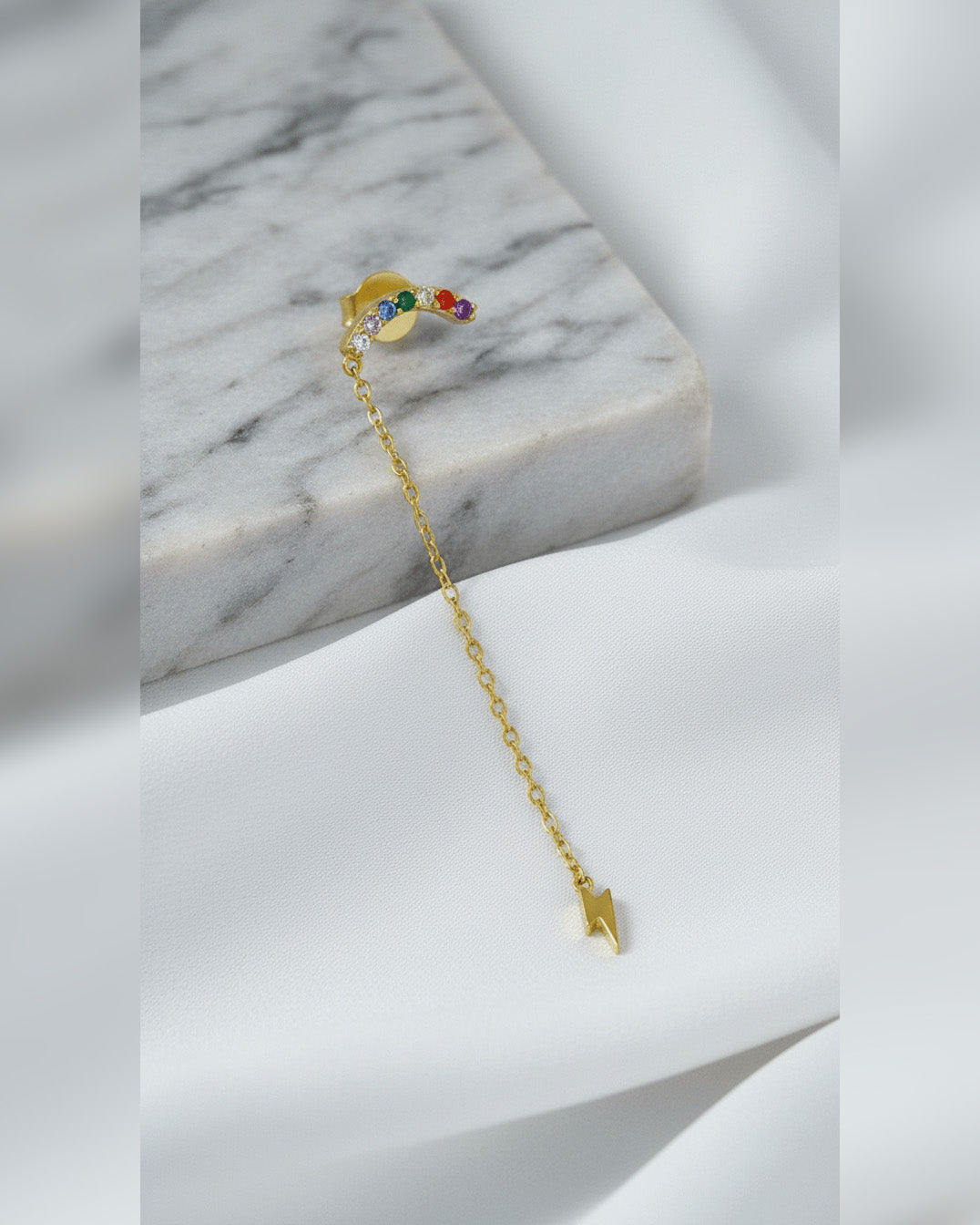 multi color curved bar with dangling bolt shape stud earring.