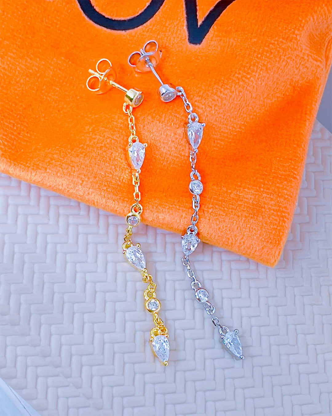 CZ long earring with round and pear shape stones.