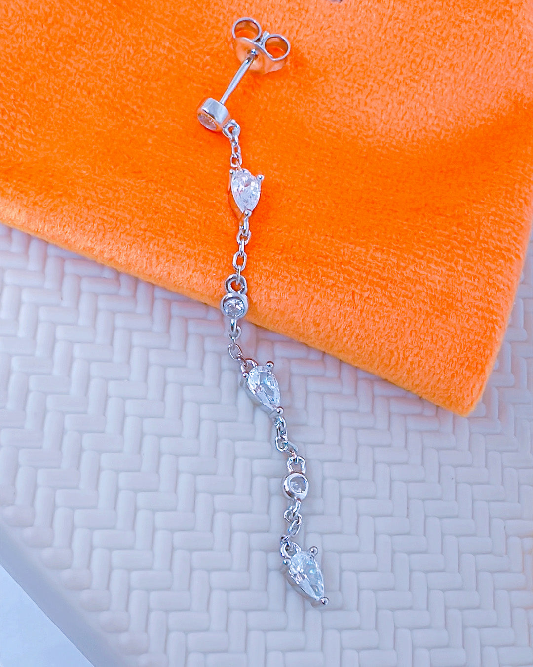 CZ long earring with round and pear shape stones.