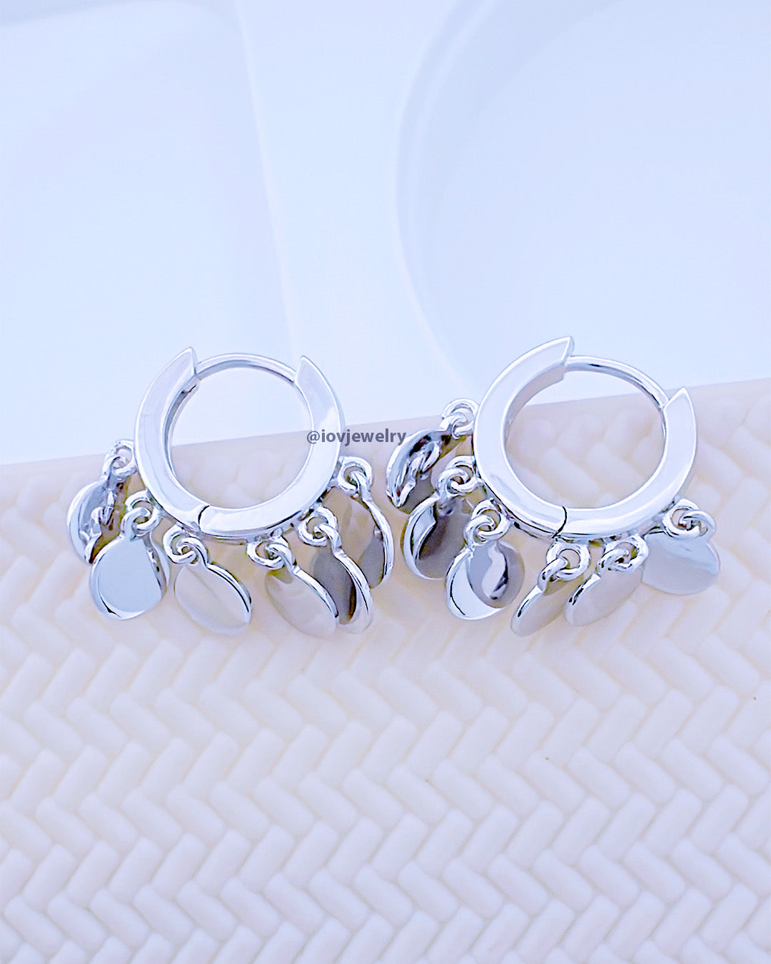 plain huggie hoop earring with dangling disc shapes.