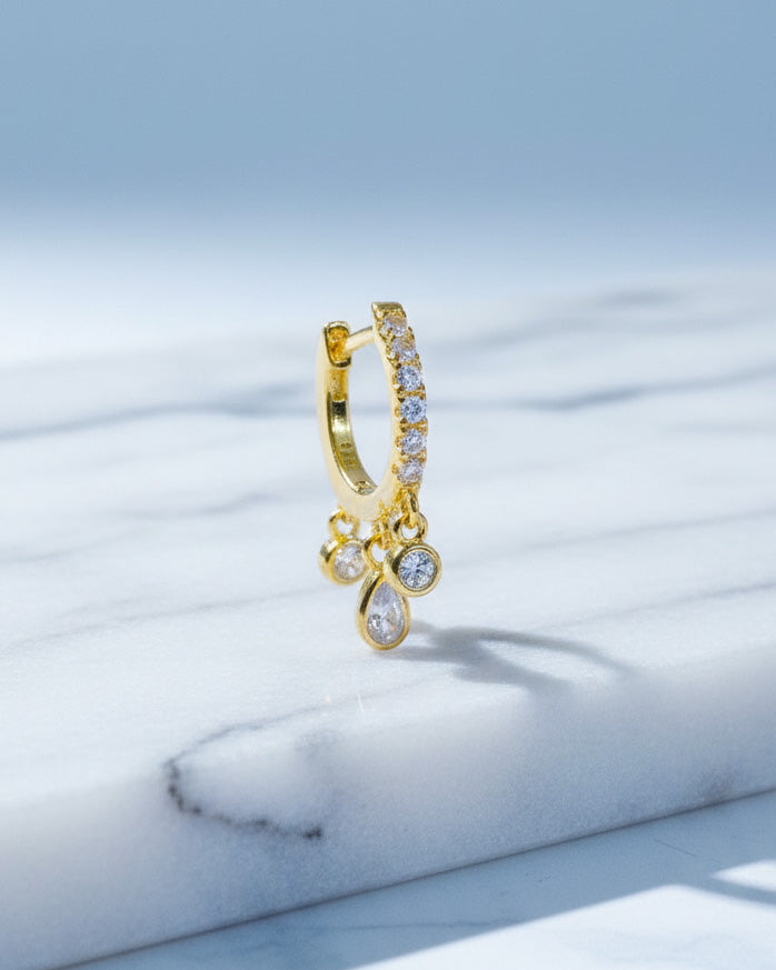 CZ huggie hoop with three dangling stones in bezel setting.