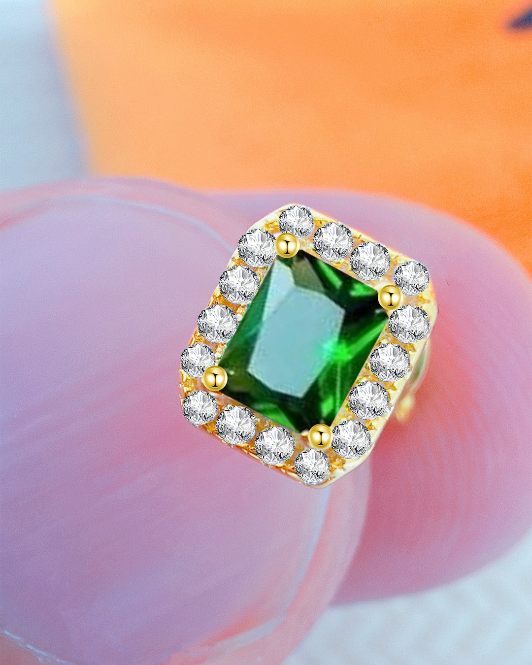 CZ emerald color rectangular stone in a halo setting stud earring.