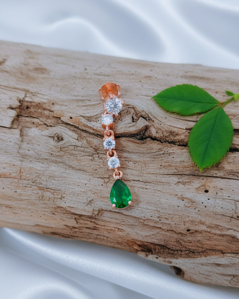white CZ line ending with emerald color pear shape stud earring.
