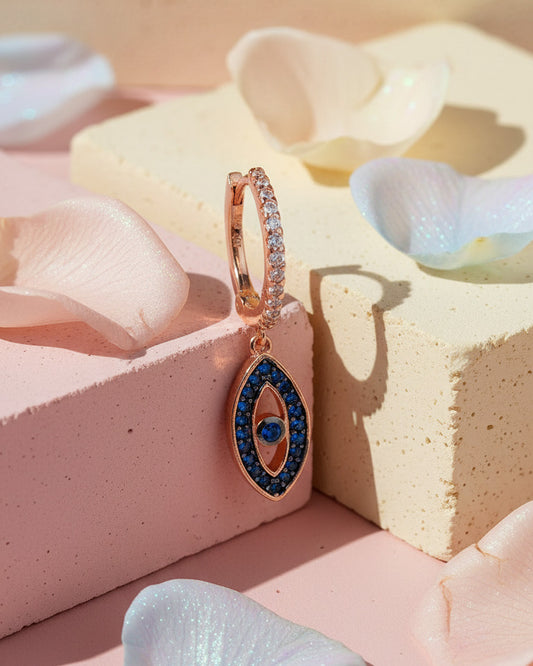 rosegold huggie hoop with dangling eye shape.