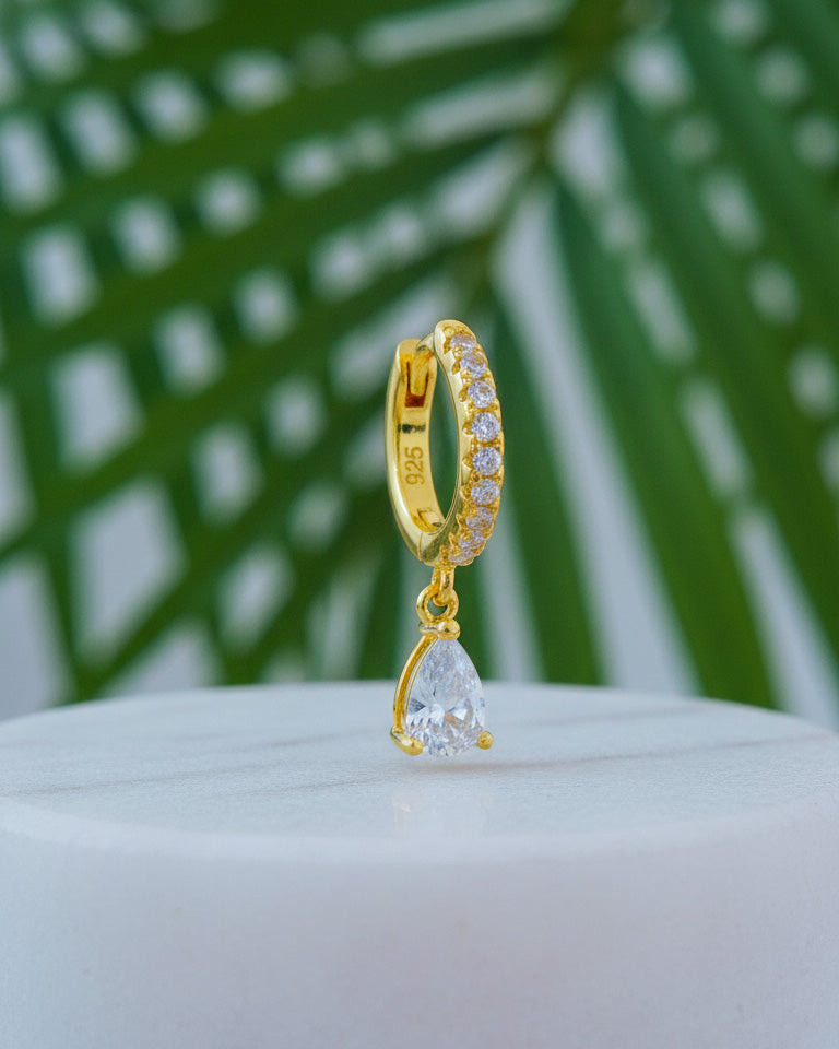 Huggie hoop earring with dangling CZ pear shape.