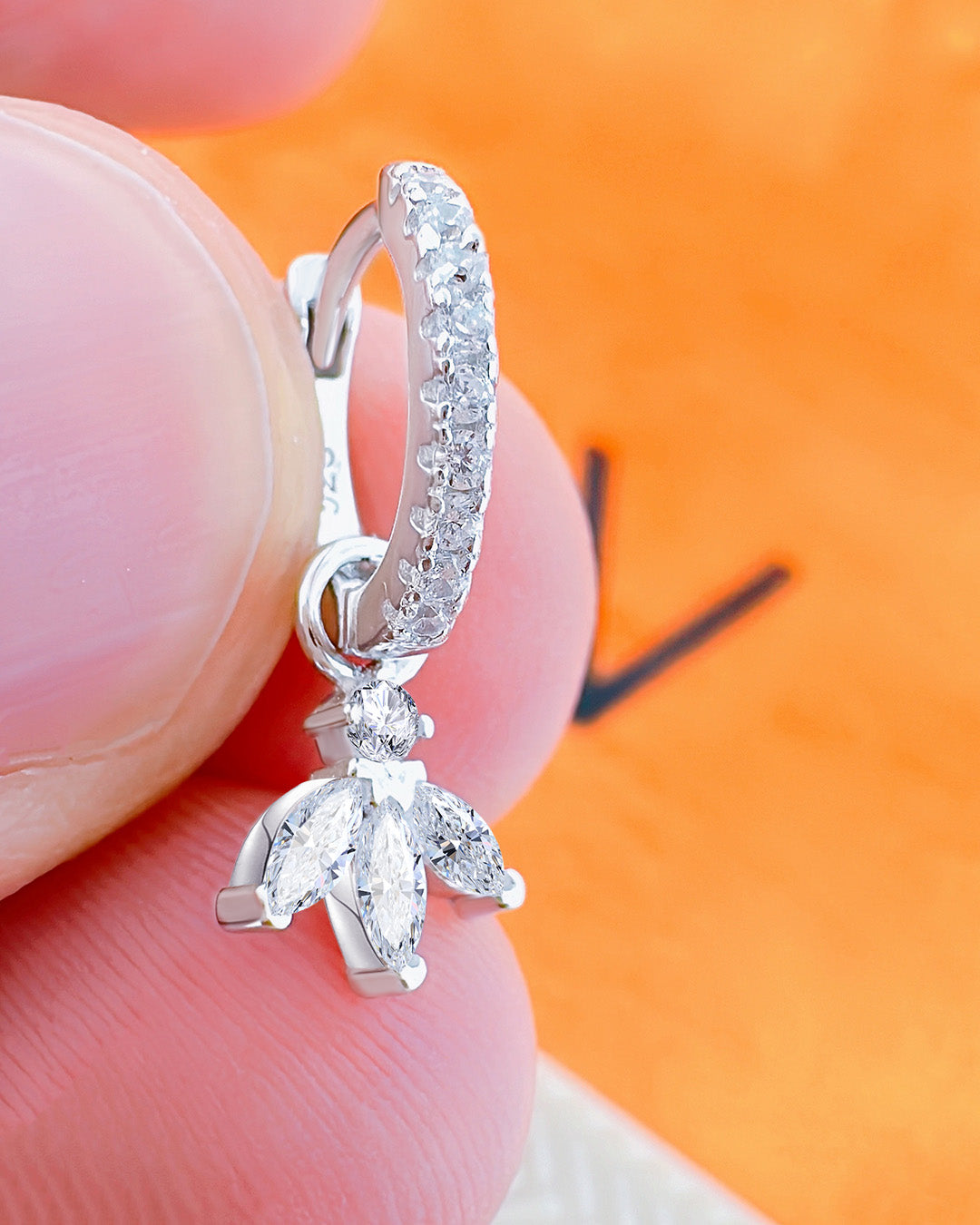 CZ huggie hoop earring with dangling marquise shape stones.