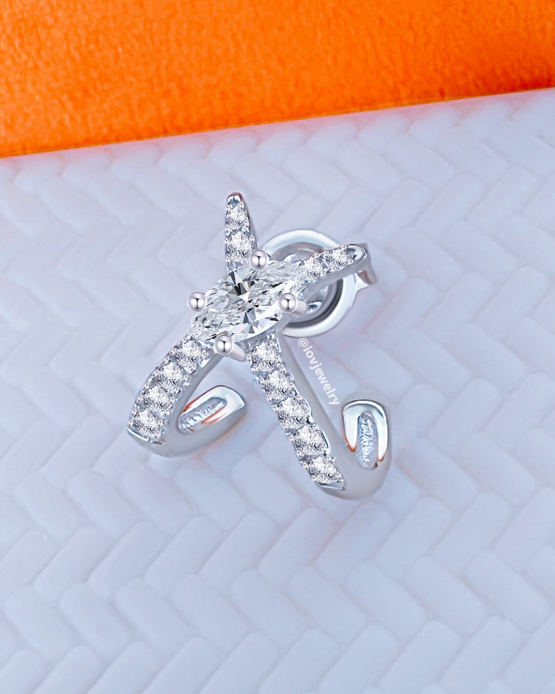 X shape huggie hoop with marquise center stone.