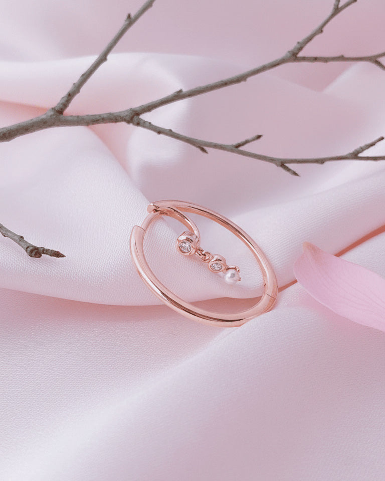 rosegold hoop earring with dangling CZ and pearl.