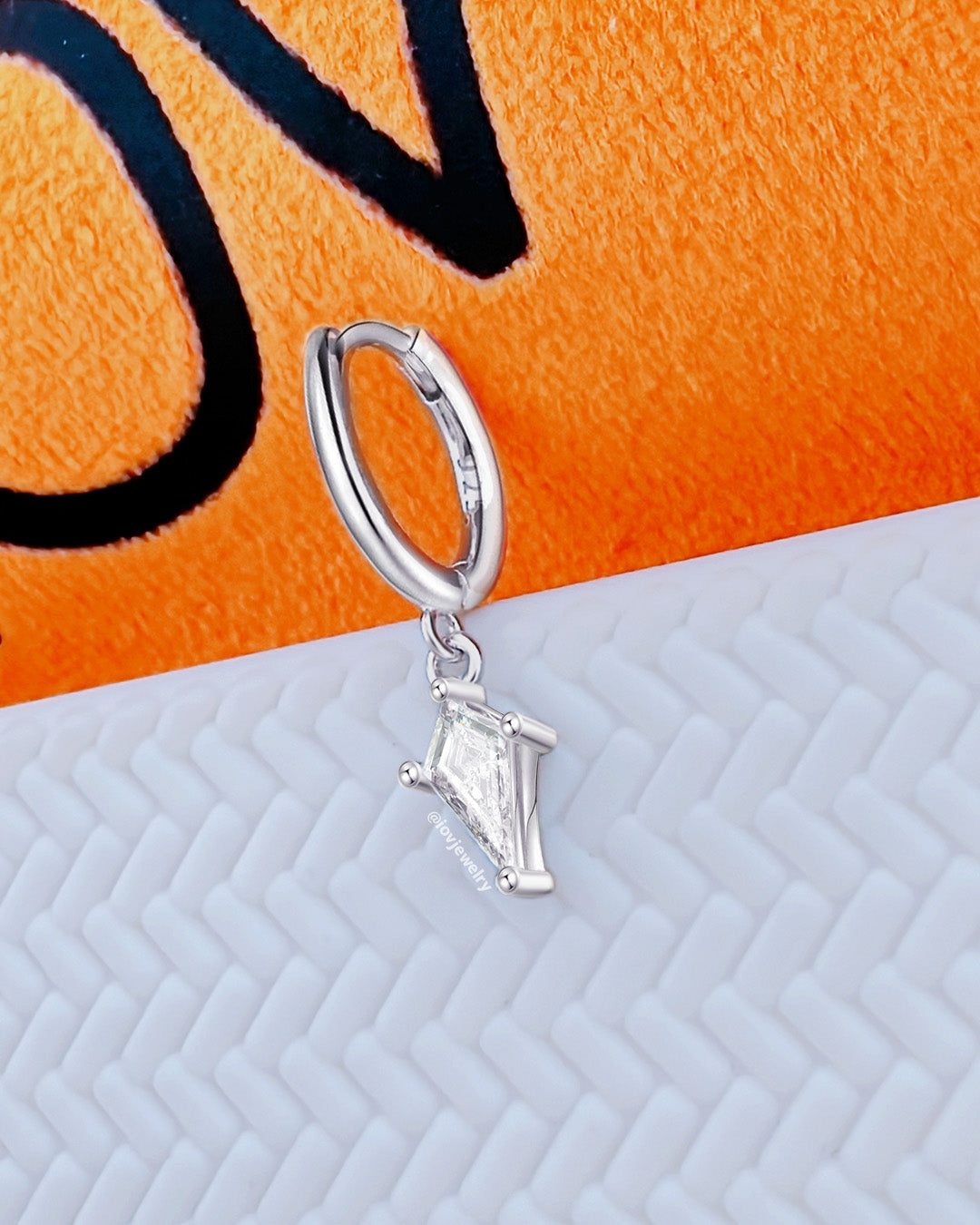 huggie hoop earring with dangling CZ kite shape.