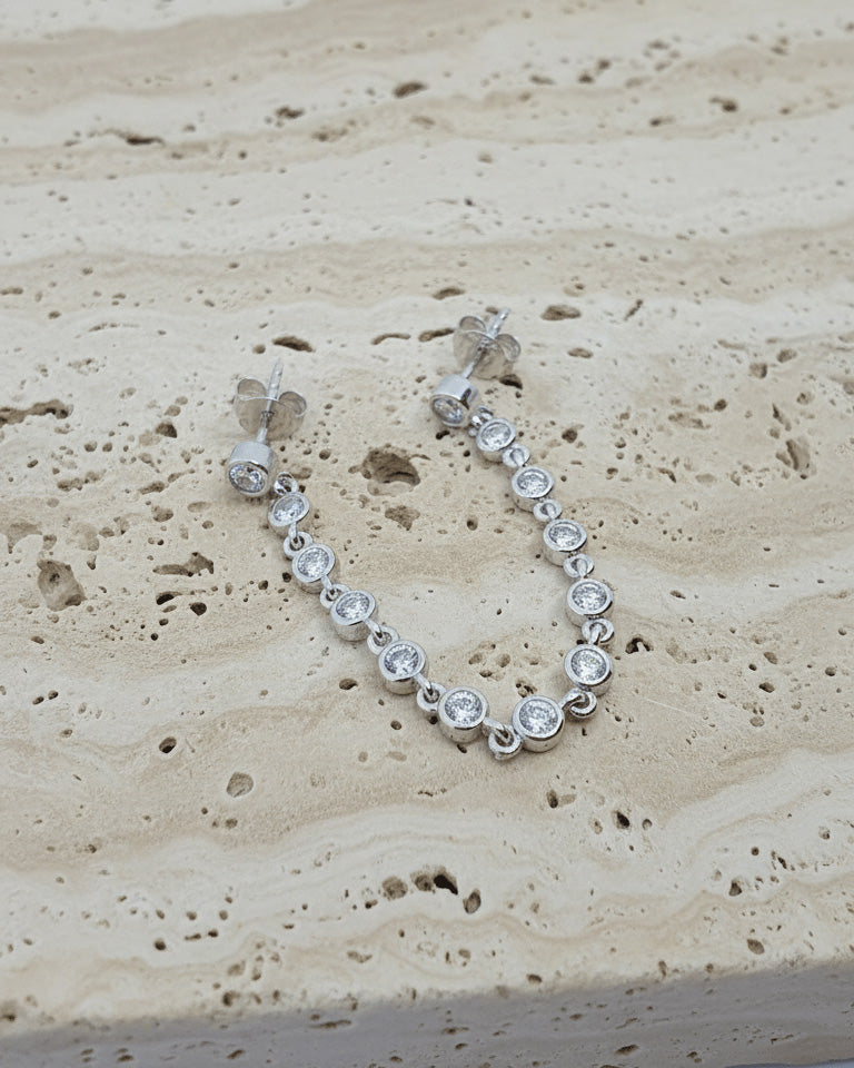 double stud earring of round stones in bezel setting.