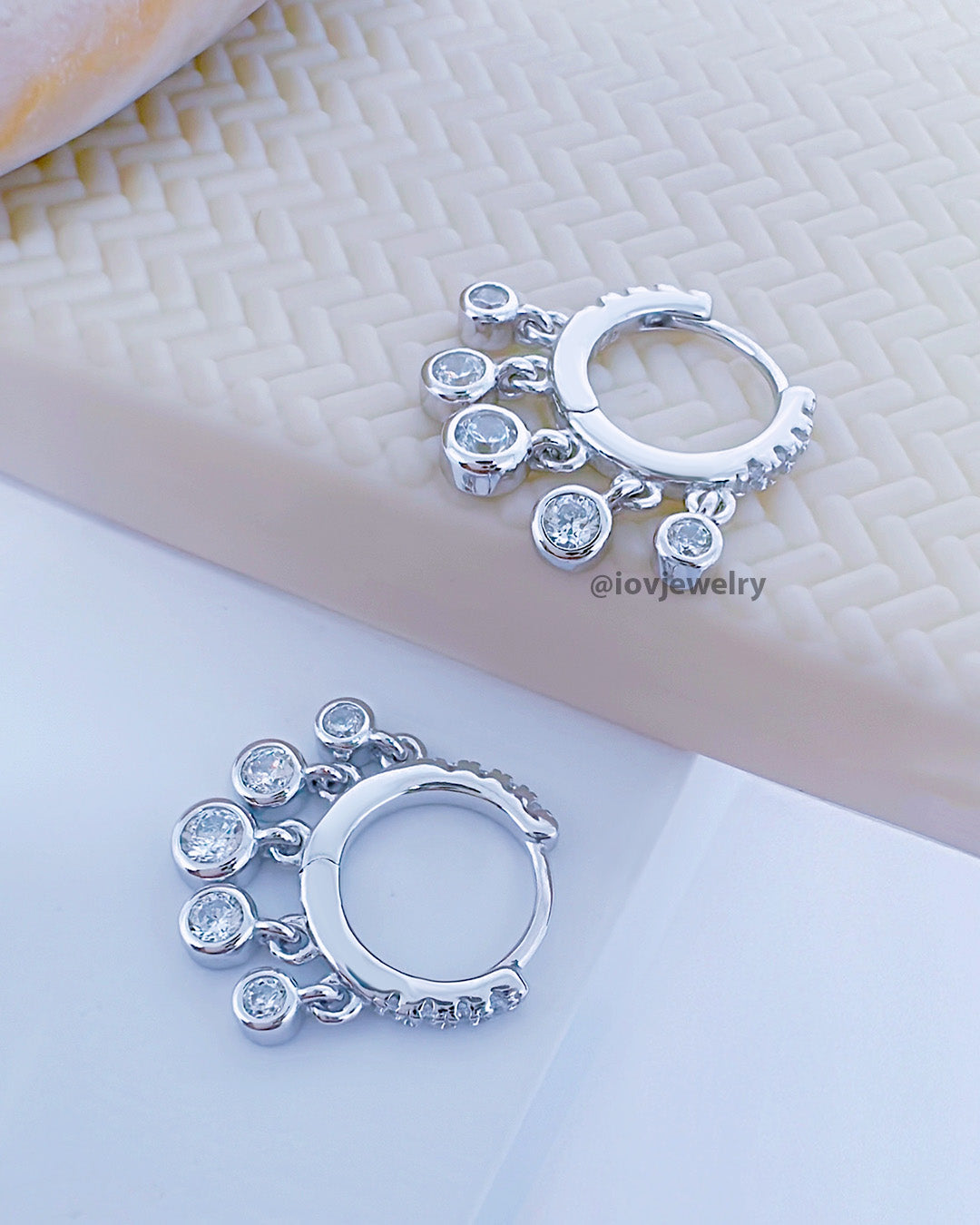 9mm huggie hoop earring with dangling CZ stones in bezel setting.
