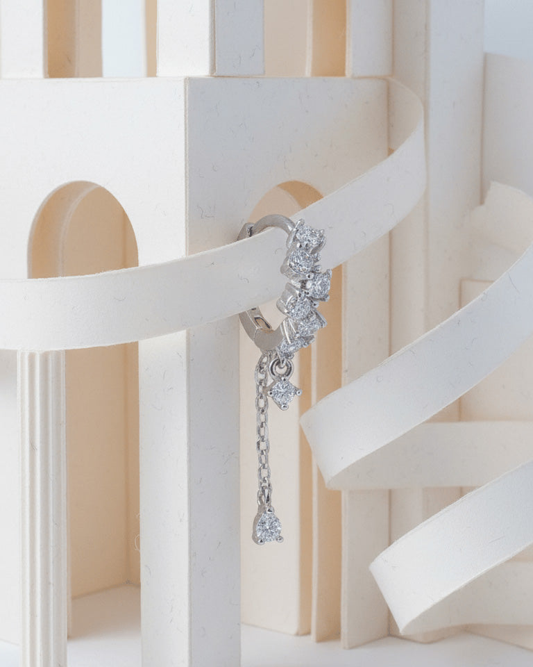 uneven Round CZ arrangement huggie hoop with dangling double chain.