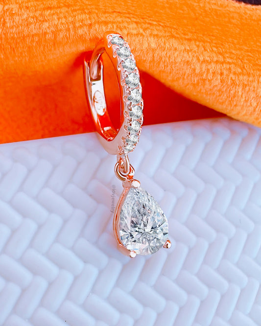 rosegold 8mm huggie hoop earring with dangling CZ pear shape stone.