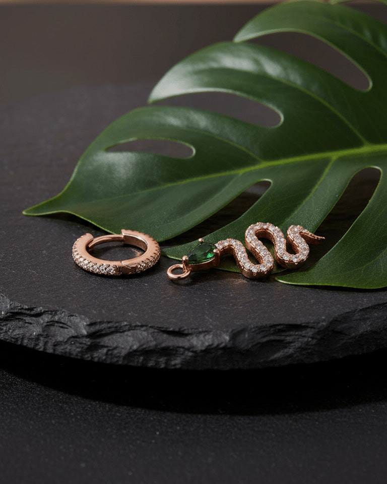 huggie hoop with dangling snake shape plated with rose gold.