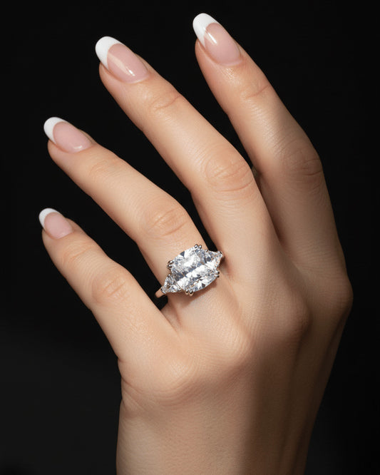 Cushion shape solitaire ring with two trillion cut side stones.