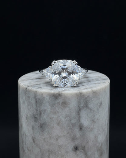Cushion shape solitaire ring with two trillion cut side stones.