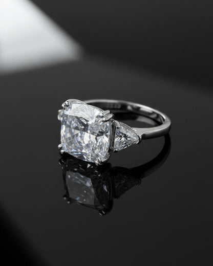 Cushion shape solitaire ring with two trillion cut side stones.