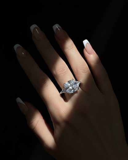 Cushion shape solitaire ring with two trillion cut side stones.