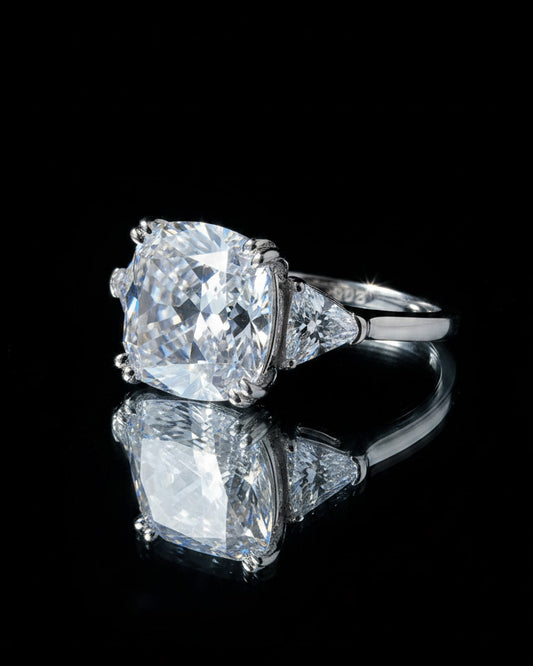 Cushion shape solitaire ring with two trillion cut side stones.