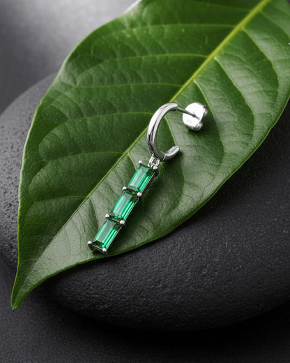 plain huggie hoop with dangling emerald and ruby color bar.