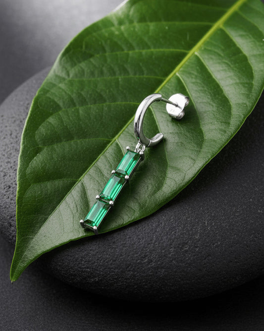 plain huggie hoop with dangling emerald and ruby color bar.