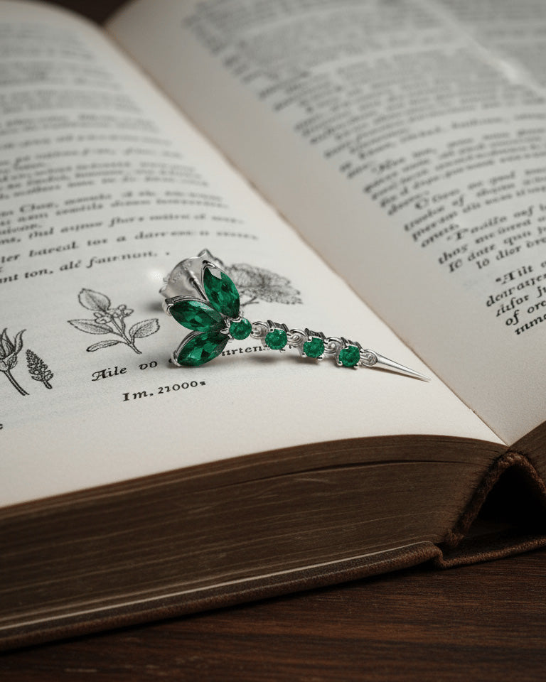 lotus shape stud earring with dangling line of emerald color stones.
