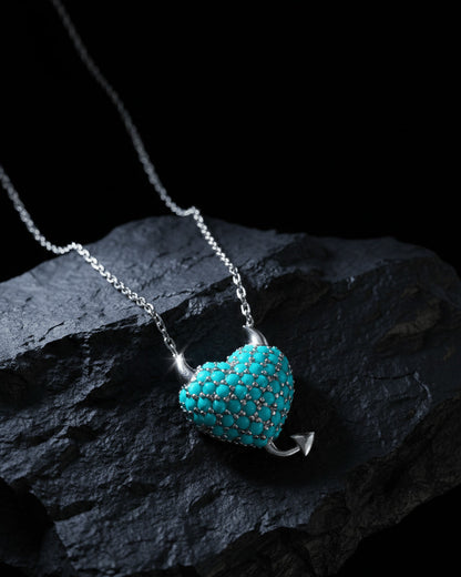 a horned turquoise studded heart shape necklace.