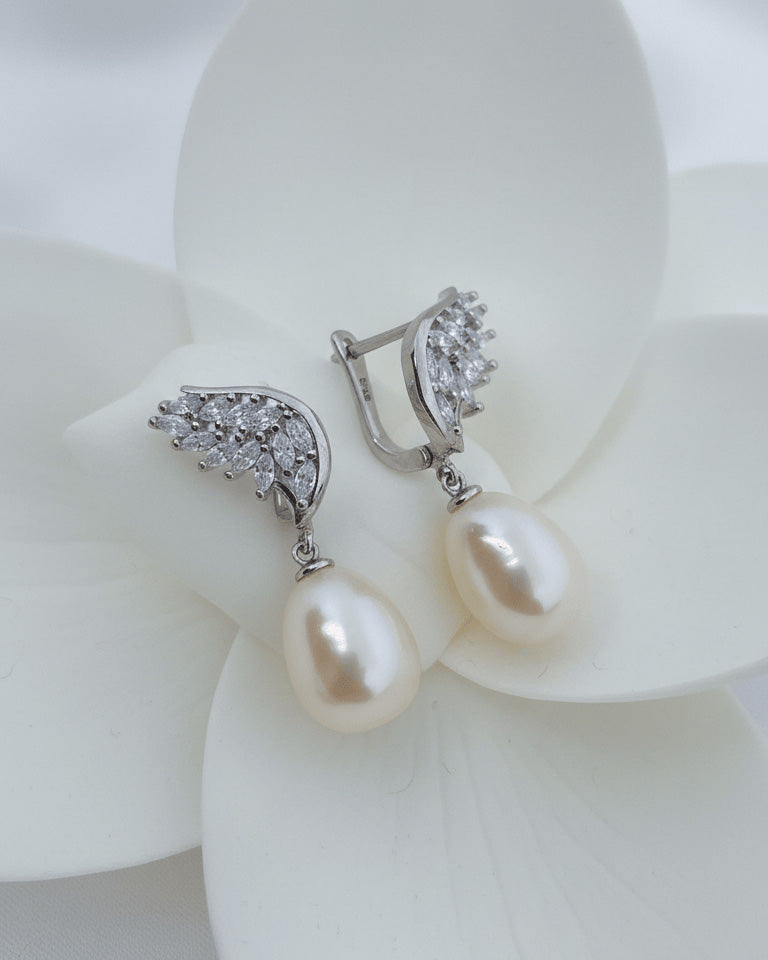 wings shape marquise clip-on earrings with dangling pearls.