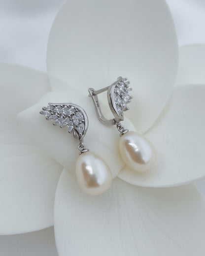 wings shape marquise clip-on earrings with dangling pearls.