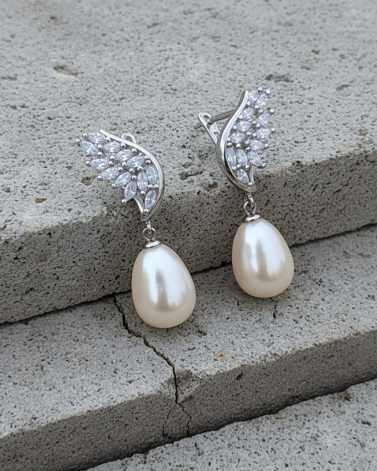 wings shape marquise clip-on earrings with dangling pearls.