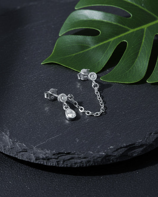 Gold 925 sterling silver double piercing chain earring with round CZ studs and pear-shaped CZ drop on slate background