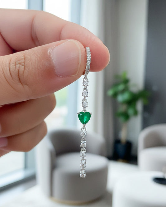 CZ huggie hoop with dangling line of CZ and emerald color heart shape.