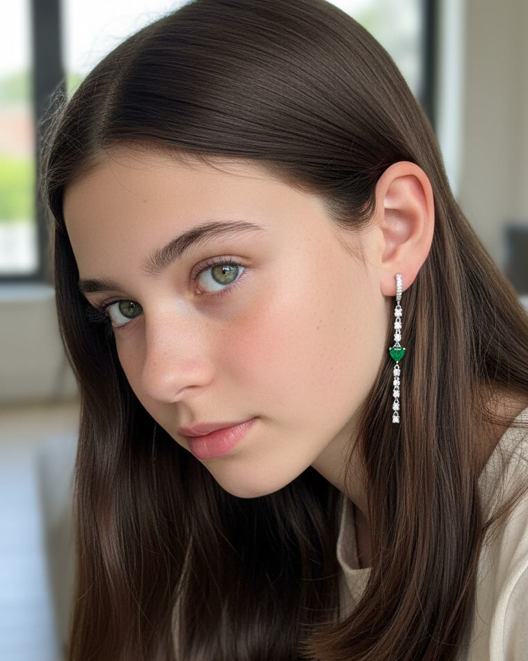 CZ huggie hoop with dangling line of CZ and emerald color heart shape.