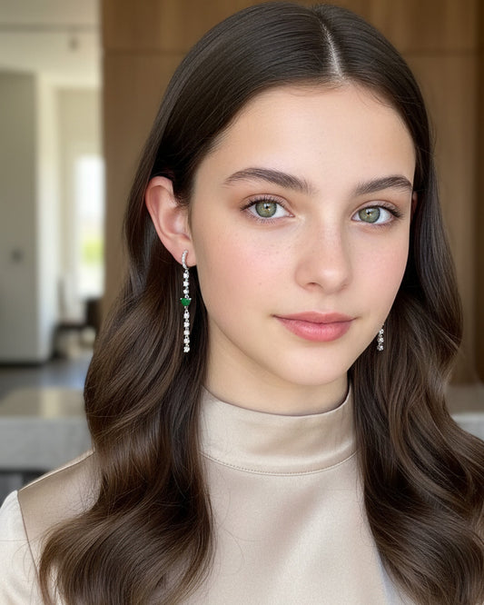 CZ huggie hoop with dangling line of CZ and emerald color heart shape.