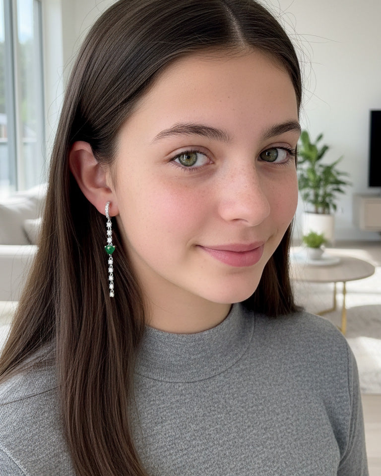 CZ huggie hoop with dangling line of CZ and emerald color heart shape.