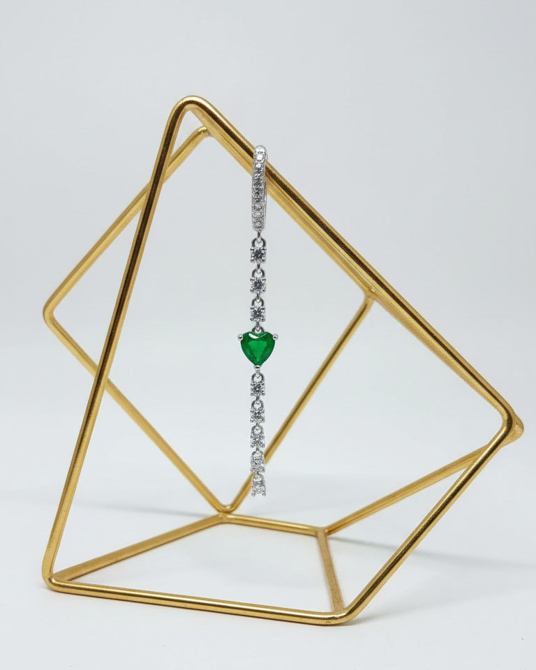 CZ huggie hoop with dangling line of CZ and emerald color heart shape.