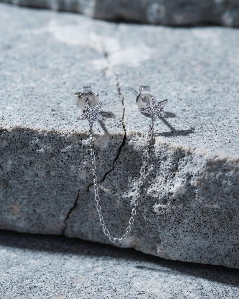 double CZ star stud earring linked with a delicate chain.