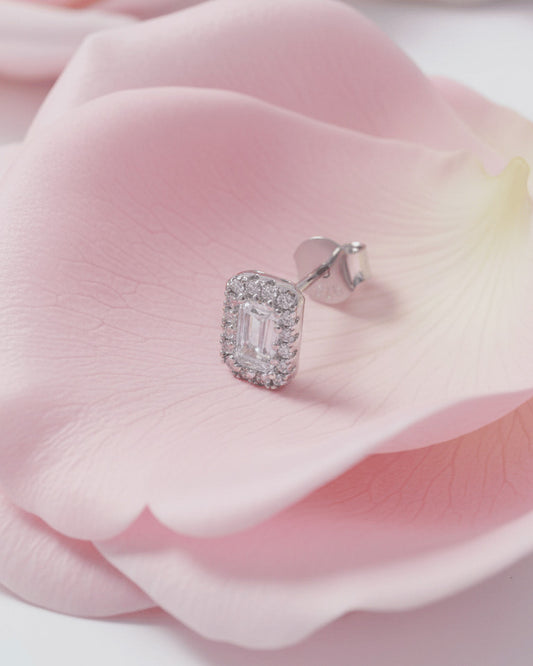 emerald cut stone in a halo setting stud earring.