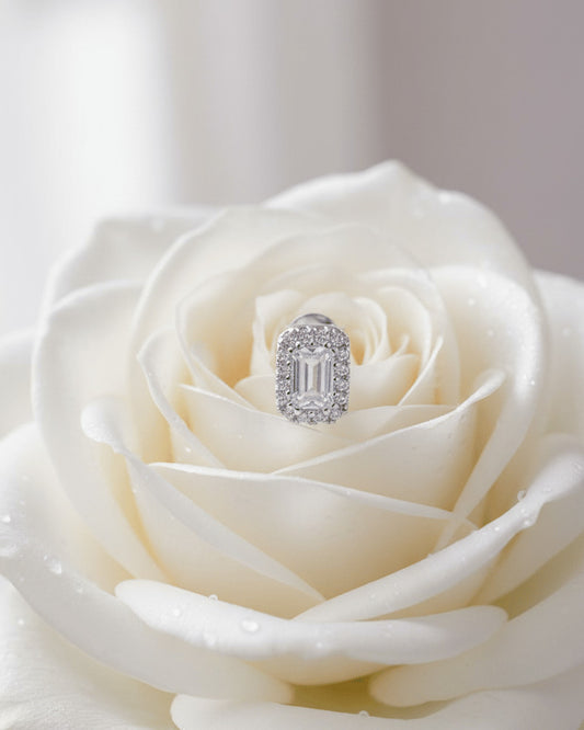emerald cut stone in a halo setting stud earring.