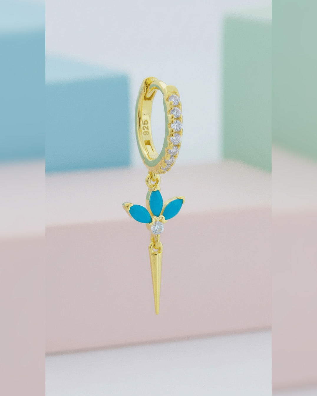 CZ huggie hoop with dangling lotus shape.