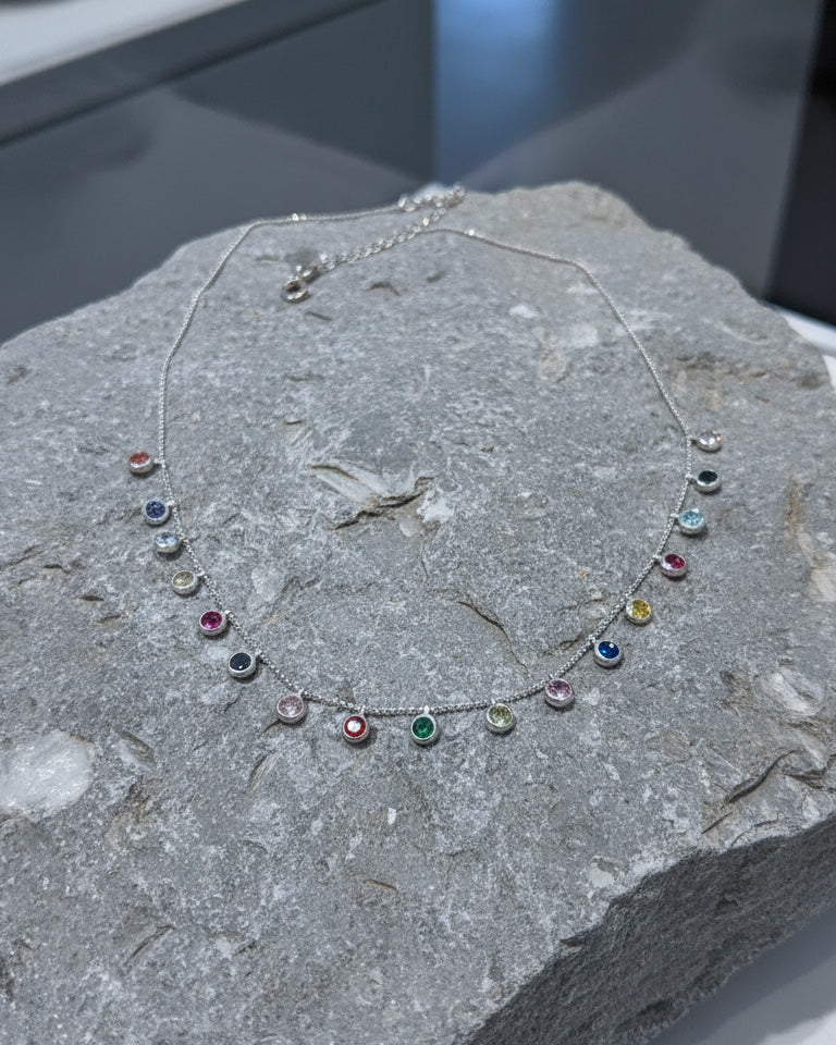 fine necklace with colored dangling CZ in bezel setting.