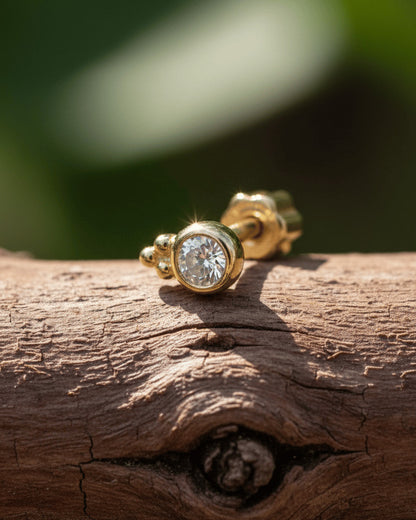 round CZ in bezel setting with three beads piercing.
