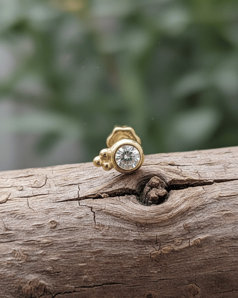 round CZ in bezel setting with three beads piercing.