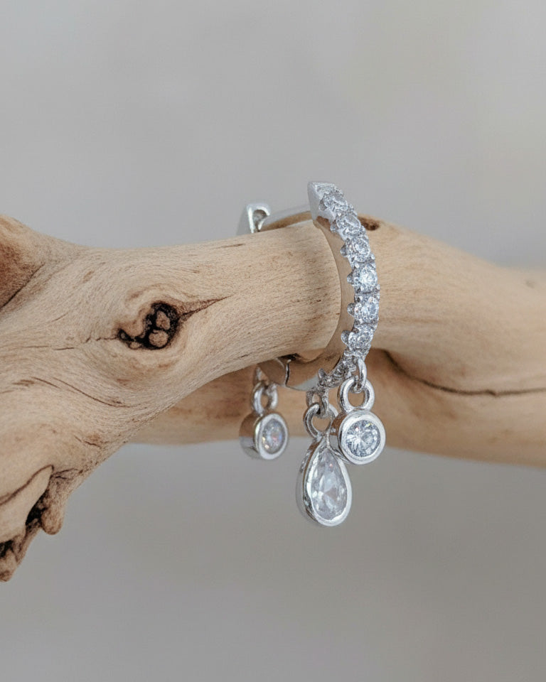 CZ huggie hoop with three dangling stones in bezel setting.