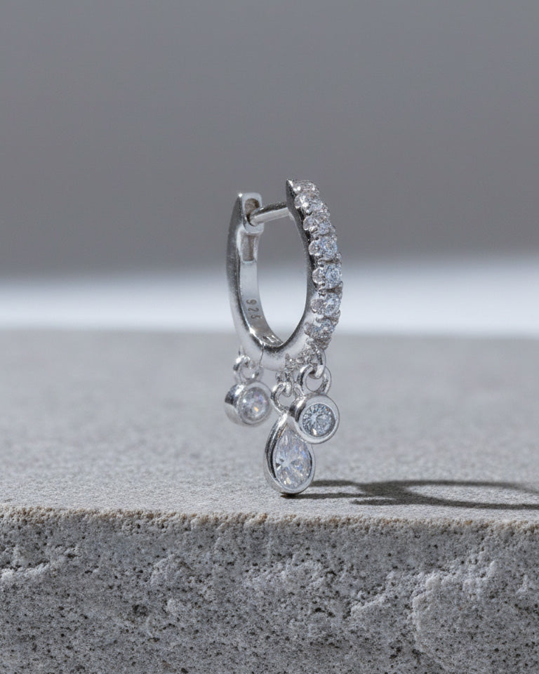 CZ huggie hoop with three dangling stones in bezel setting.